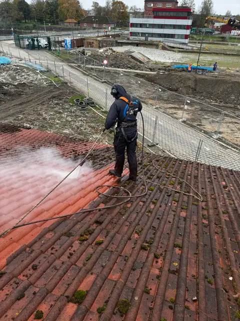 Mitarbeiter mit Sicherheitsausrüstung bei der Dachreinigung