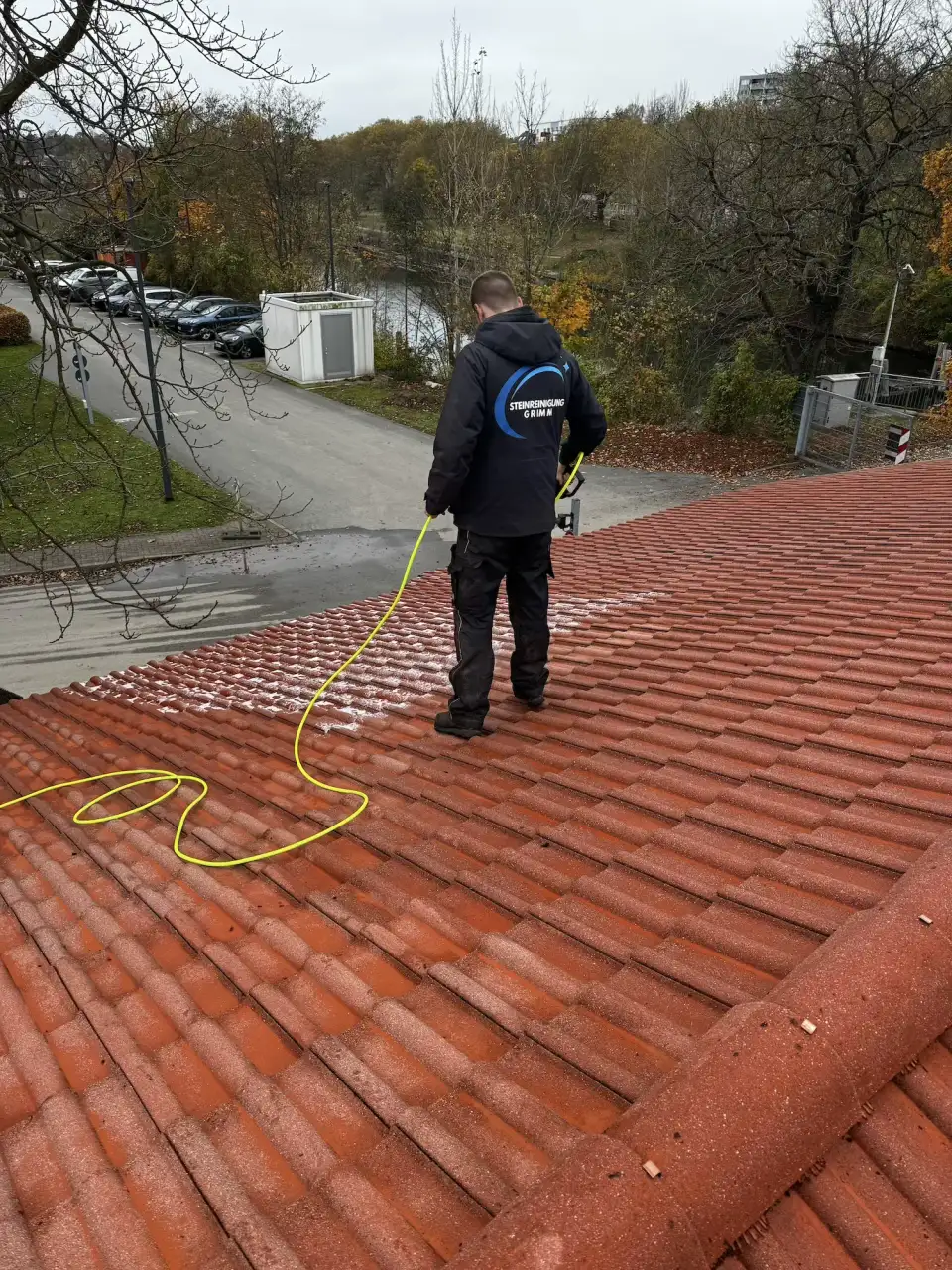 Mitarbeiter von Steinreinigung Grimm bei der Dachpflege auf einem Ziegeldach