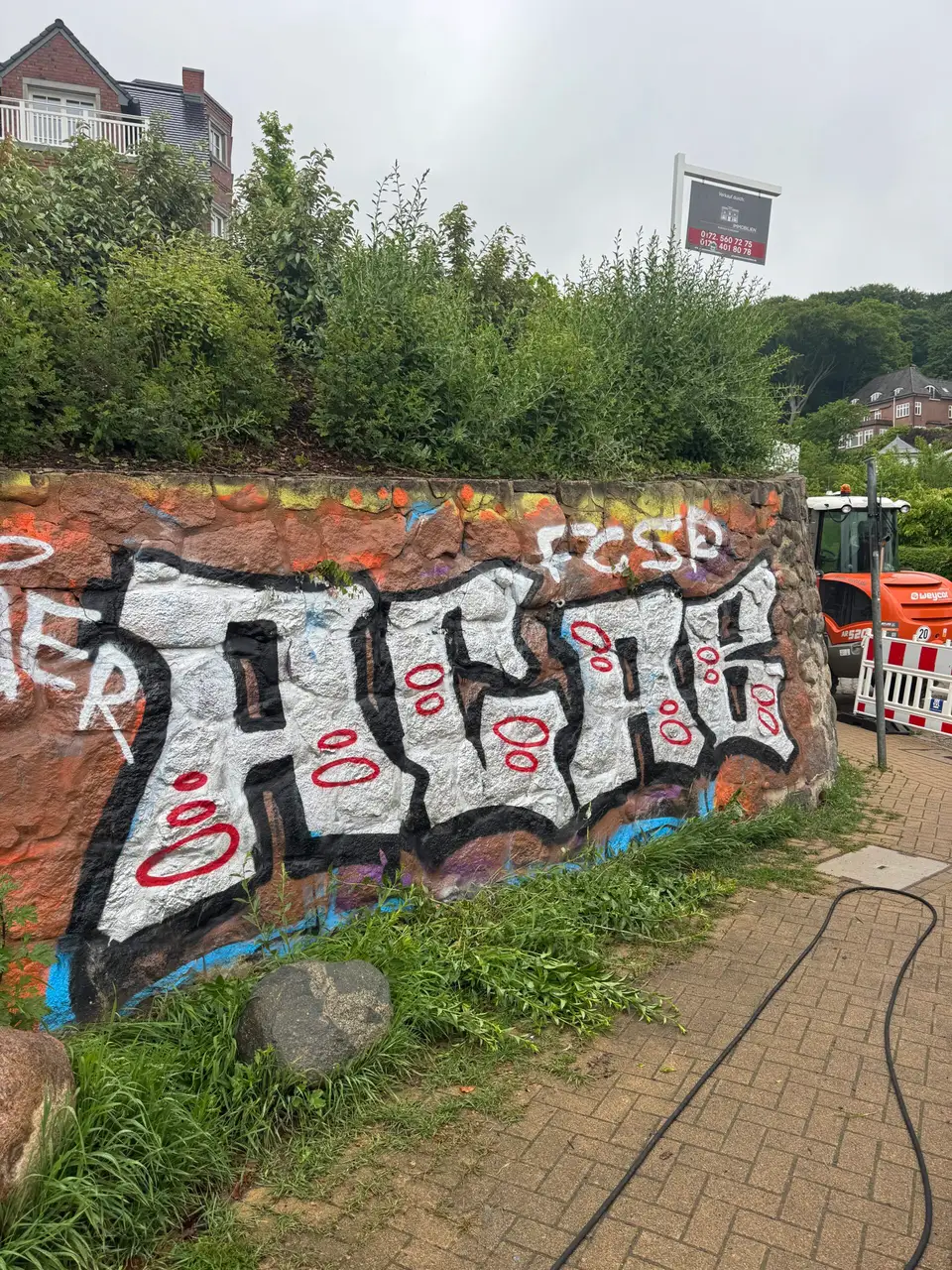 Hauswand in Hamburg-Blankenese mit Graffiti vor der Entfernung
